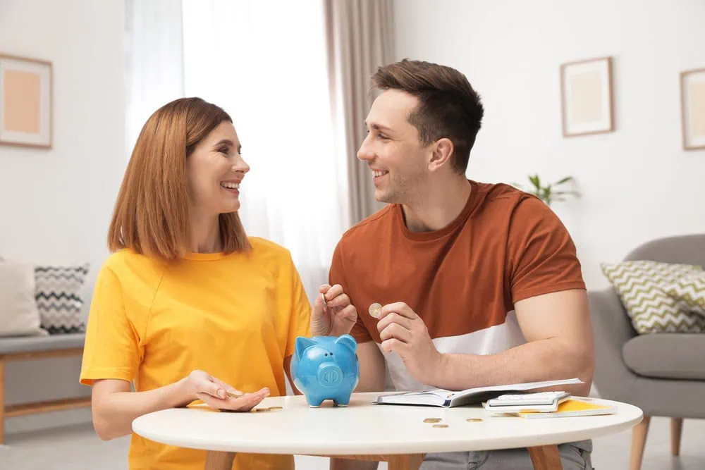 bigstock-Couple-Putting-Coins-Into-Pigg-294935341